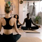 Group of adults meditating in a serene yoga class setting for relaxation.